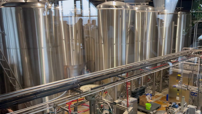 Large steel tanks and automated bottling equipment in a contemporary beverage production facility