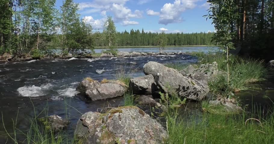 High-quality footage of a flowing river moving through a beautiful natural landscape. Clear freshwater currents glide past rocks and greenery, creating a peaceful and refreshing outdoor scene. Ideal for themes of nature, environment, travel, relaxation, wilderness, and ecological concepts.
