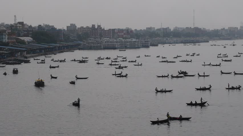DHAKA, BANGLADESH – MAY 09: Small wooden boats are seen carrying passengers to cross the Buriganga river in Dhaka, Bangladesh on May 09, 2021.