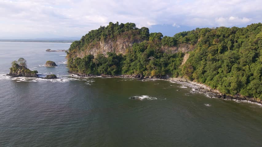 The beautiful, lush coastline of pacific Costa Rica. Aerial pull back reveal