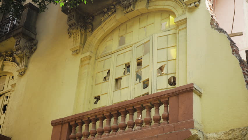 The windows of a formerly beautiful old building are broken, now derelict and abandoned in Colonia Juárez, Mexico City.
