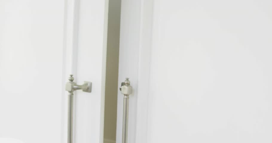 Animation of envelope icon in circles over senior smiling woman opening door. Digital composite, multiple exposure, business, abstract, message, welcoming and retirement concept.