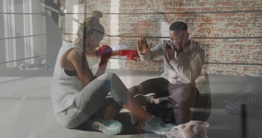 Two people practicing boxing techniques in gym with motivational overlay animation. fitness, training, exercise, sports, workout, martial arts