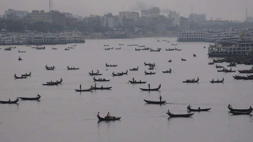 DHAKA, BANGLADESH – MAY 09: Small wooden boats are seen carrying passengers to cross the Buriganga river in Dhaka, Bangladesh on May 09, 2021.