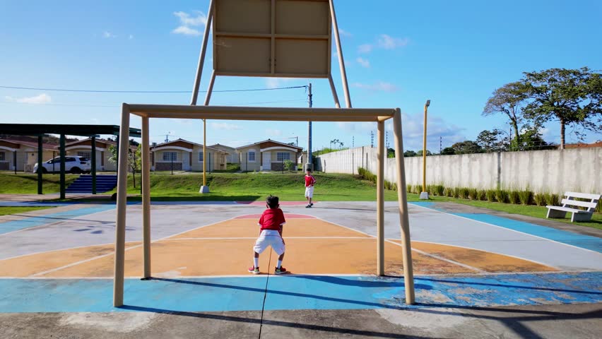 A young boy is playing basketball in a park
