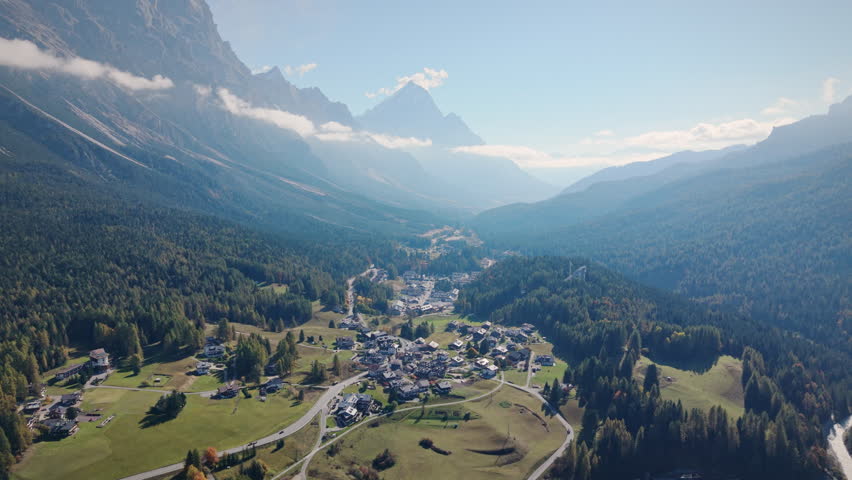 Aerial view of scenic lush green valley landscape of Cortina d Ampezzo downtown with residential and pine forest on hill in Dolomites, Italy
