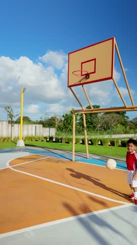 A young boy is playing basketball on a court