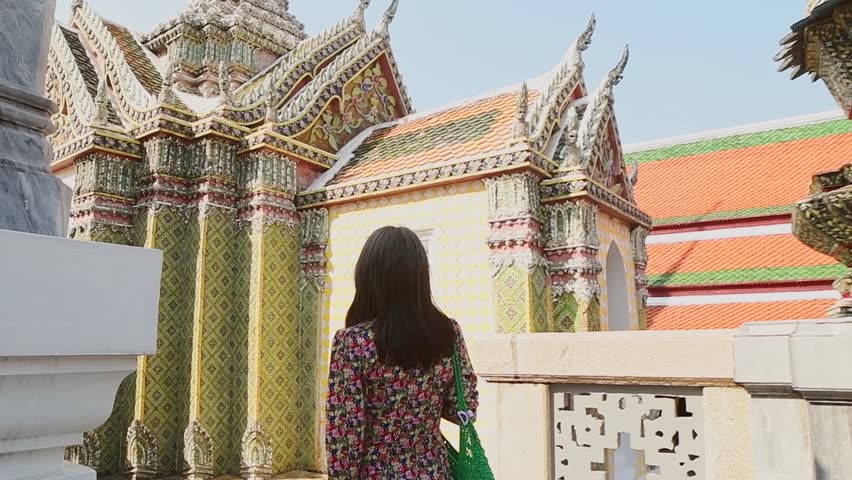 Bangkok, Thailand - 15th february, 2024:woman sightseeing Bangkok Grand Palace complex Wat Phra Kaew, tourist walk along ornate corridor with colorful mosaic tiles, Thai temple architecture