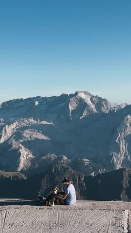 Woman Sitting with Dog Overlooking Valley
Peaceful lifestyle shot of woman petting dog while enjoying alpine panorama.