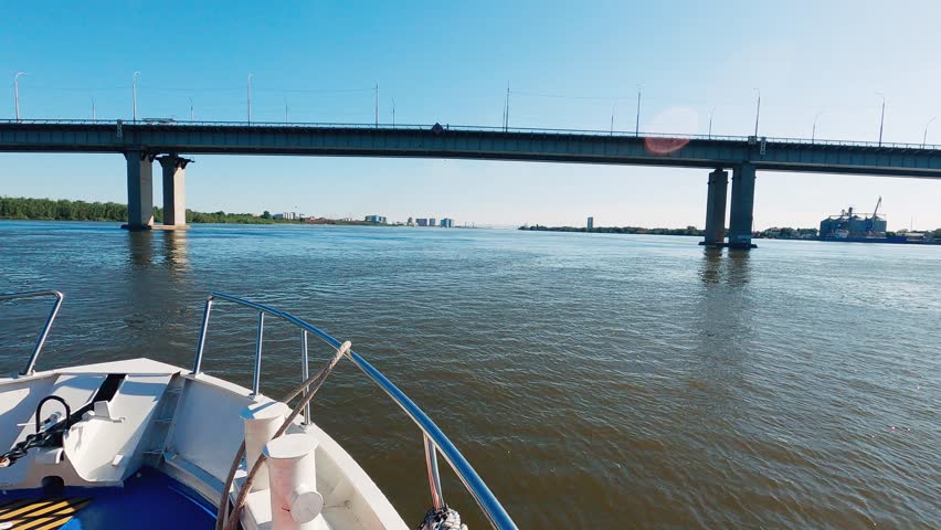 A time lapse from the bow of a river cruise boat, passing under a large concrete bridge. It