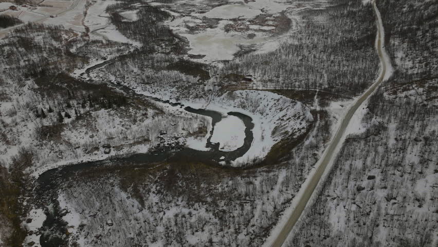 Aerial descent and tilt up over a snow covered forest in a desolate valley. Troms, Finnmark norhern Norway.
4k drone shot.