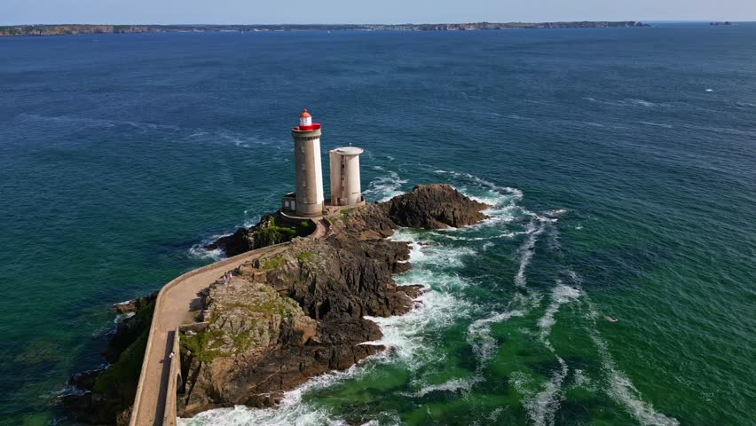 Aerial of Petit Minou lighthouse centered on rocky coast near Plouzane, Brittany, France, establishing pullback