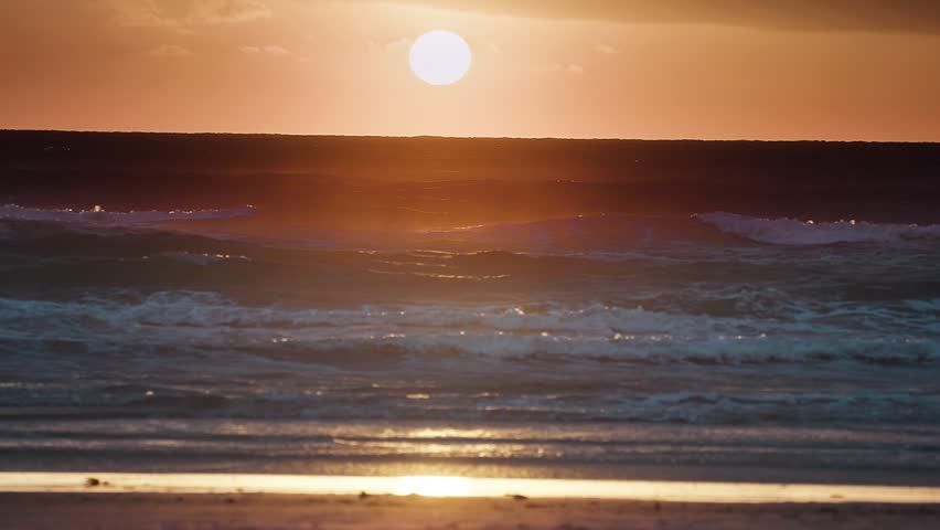 Beautiful sunset above the sea on the Danish coast. Slow-motion, pan left.