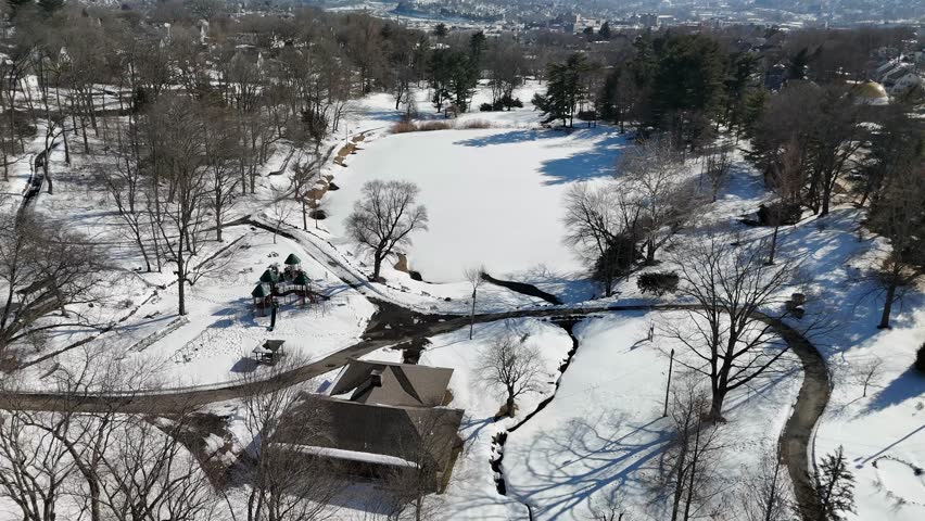 4K Aerial View of Snowy Fulton Park and Frozen Pond in Waterbury, Connecticut
