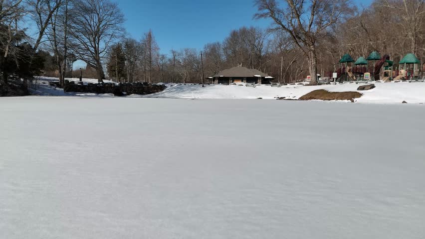 4K Aerial View of Snowy Fulton Park and Frozen Pond in Waterbury, Connecticut
