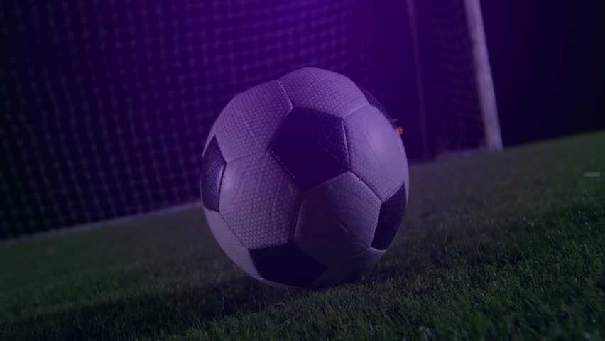 Male player entering right, foot striking ball as purple sports HUD pulsing, fading, for marketers. Night, stadium, grass, pitch, rings, overlay, motion