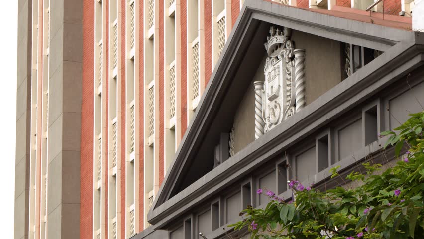 A low angle shot of Manila City Hall with national flags waving under daylight