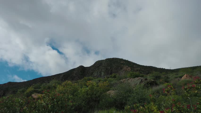 White clouds drift over the green peak of Blue Ridge Trail
