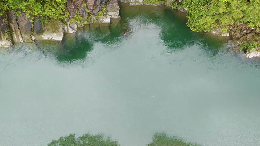 A serene aerial view of clear water surrounded by dense green vegetation, showcasing the natural beauty of Agua Clara in Buenaventura.