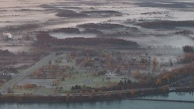 Serene push in shot above a misty Canadian landscape, revealing an autumn forest and a quiet cemetery shrouded in thick morning fog. - Powered by Shutterstock - Get 15% off with code: PIKWIZARD15