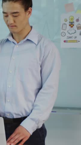 Vertical video: Man placing hands on laptop initiating code overlay obscuring board in tech demo. Startup, innovation, presentation, boardroom, office, programming, vertical video