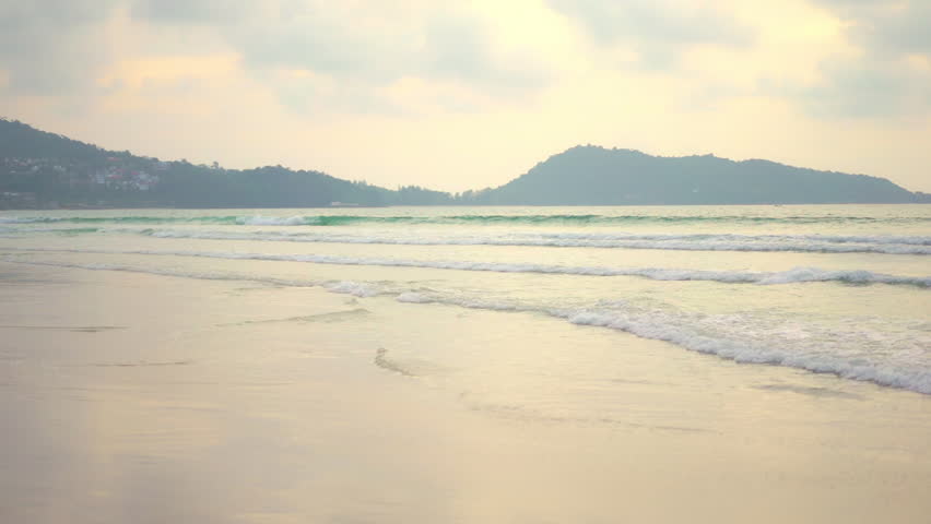 Woman Stepping in Frame on Secluded Beach Puts on Sun Hat. Rack Focus.