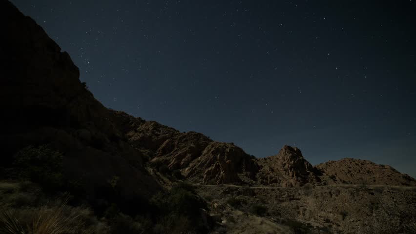 Time lapse of stars above a rocky mountain ridge
