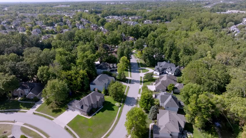 Neighborhood homes in Carmel, Indiana with drone video moving forward.