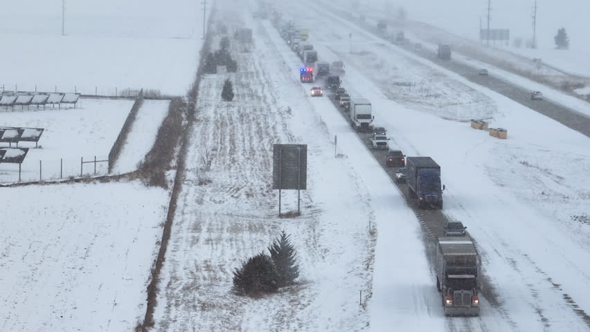 Aerial view over of a traffic jam on a snowy highway, winter snowstorm in USA