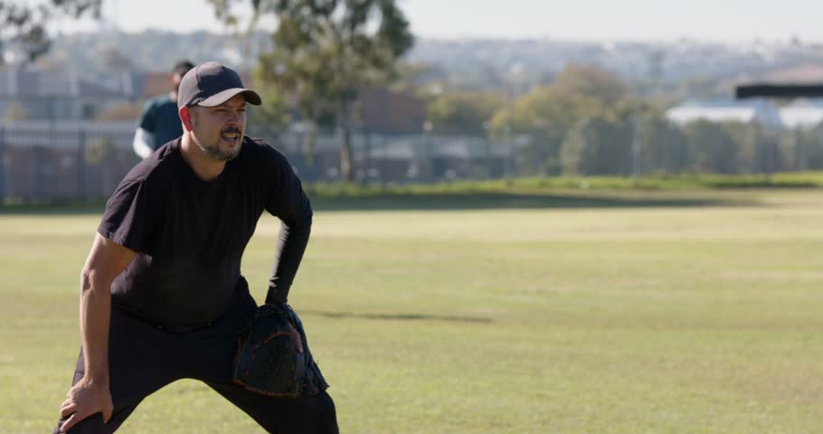 Softly rolling ball causing man diving headfirst to catch in glove, cheering teammate on field. Athletic, teamwork, action, outdoors, competitive, motion, sport