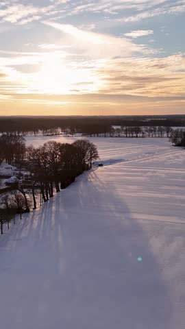 Aerial View of Snowy Winter Landscape at Sunset.