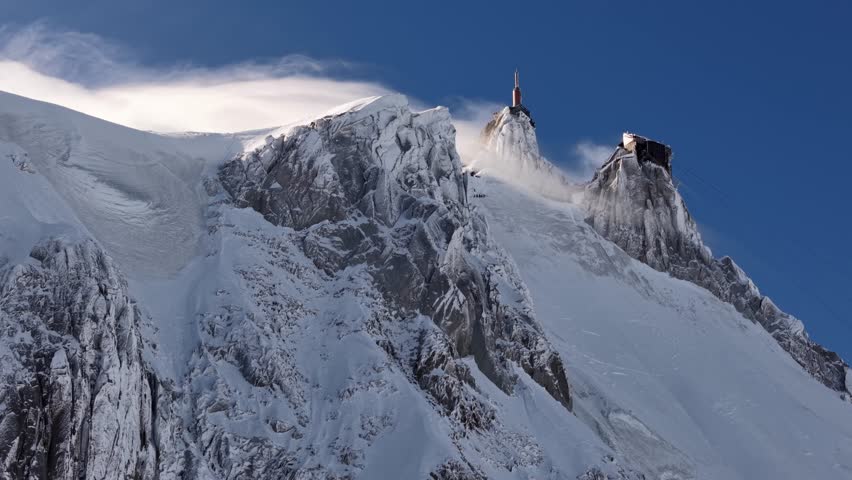 Snowy Aiguille du Midi peak and cable car in Chamonix France