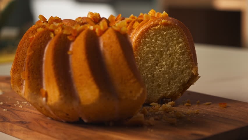 Glazed Easter Bundt Cake Topped With Chopped Nuts Being Sliced With A Knife. close-up shot