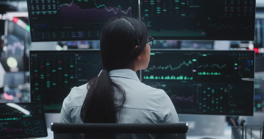 Woman With Long Tail Sits Sophisticated Workstation in Huge Innovative Digital Center. Concepts of Global Exchange, International Market Connectivity, and Large Scale Corporate Financial Management.
