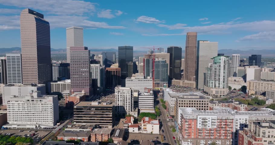 Wide skyline tracking left medium aerial of downtown Denver under clear sky Colorado USA