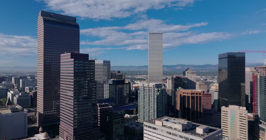 Wide skyline establishing tilt down of downtown Denver in bright noon, aerial drone overview