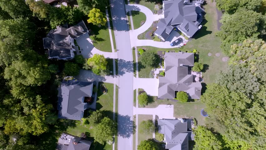 Neighborhood homes in Carmel, Indiana with drone video tilting up.