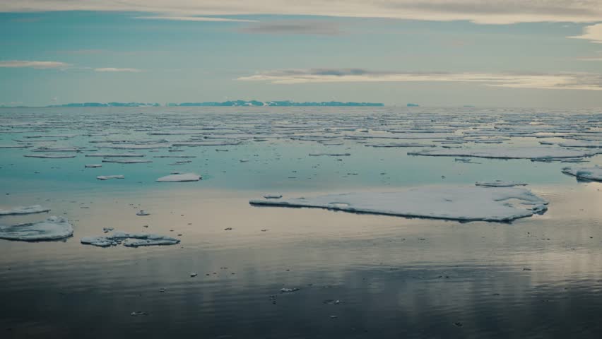 Travelling through Arctic sea ice with Svalbard mountains on horizon