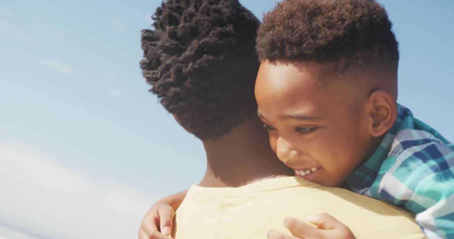 Camera moving revealing smiling son, father holding while social icons spreading around them for PR. Parent, child, outdoor, beach, horizon, vibrant, bond