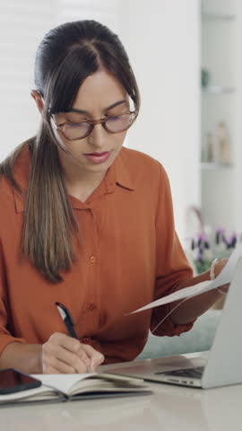 Woman, laptop and documents with review for remote work from home, typing and admin job with notebook. Person, computer and virtual assistant with paperwork, feedback and freelance project at house