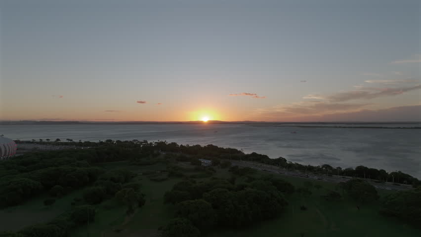 Aerial view of sunset over Guaiba Lake above Parque Marinha with boats and waterfront traffic, Porto Alegre, Brazil.