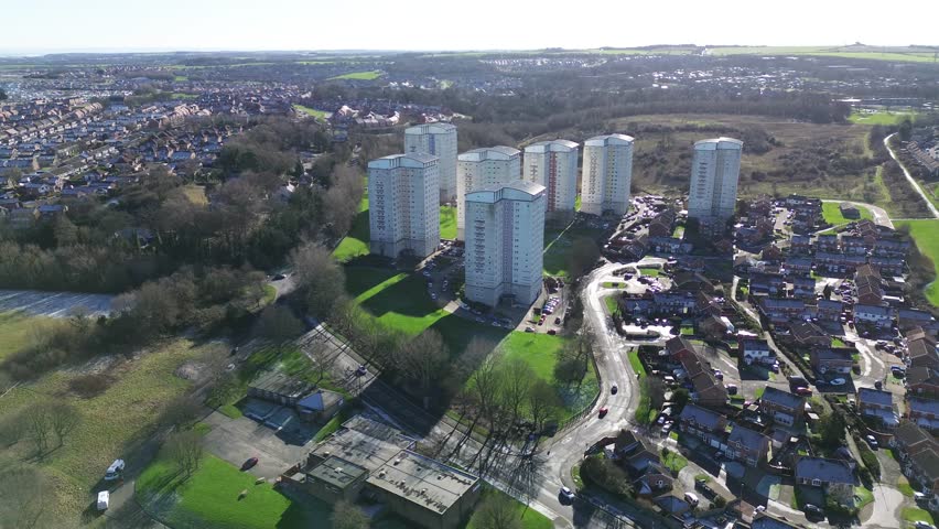 Gilley law towers, Silksworth aerial orbit right showing Sunderland high-rise housing blocks, green spaces and surrounding suburbs on a bright clear day, UK establishing shot.