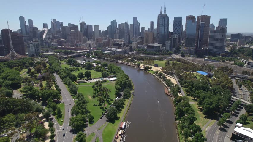 Aerial view on a sunny day of the Yarra River in the foreground and the Mebourne city skyline in the distance, Victoria, Australia. December 2025