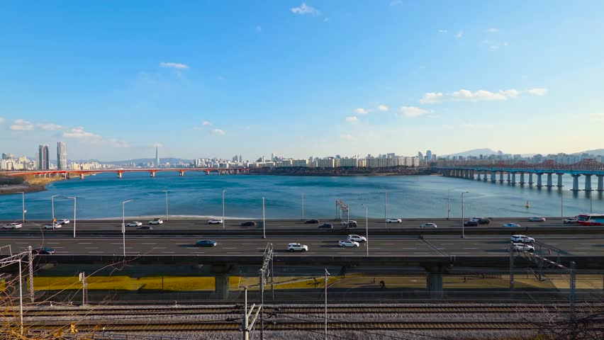 Real-time aerial view of Gangbyeonbuk-ro expressway traffic and subway tracks along Han River with Seongsu and Donho Bridge in Seoul