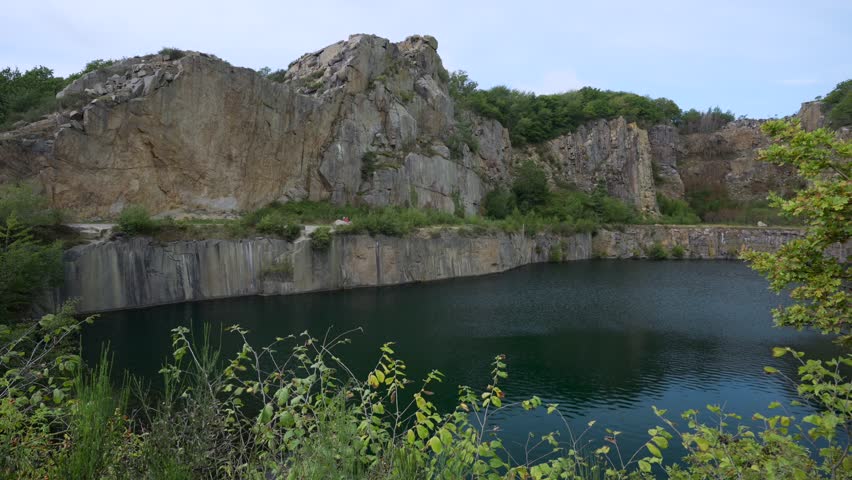 Opal lake in Bornholm, Denmark. Calm lake in summer, windless, covered with deep green water, cliffs, rocks.