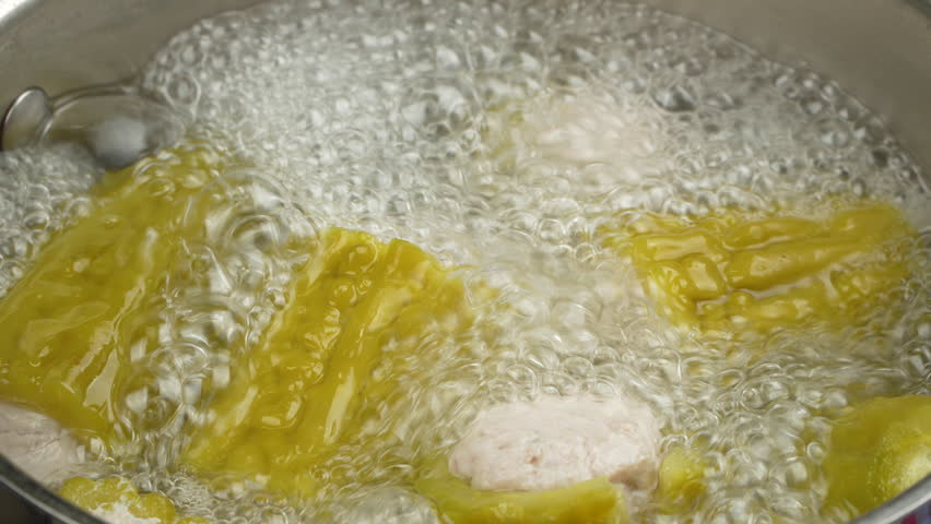 Close up of traditional Vietnamese stuffed bitter melon soup with minced pork fully cooked and vigorously boiling in a pot for Lunar New Year