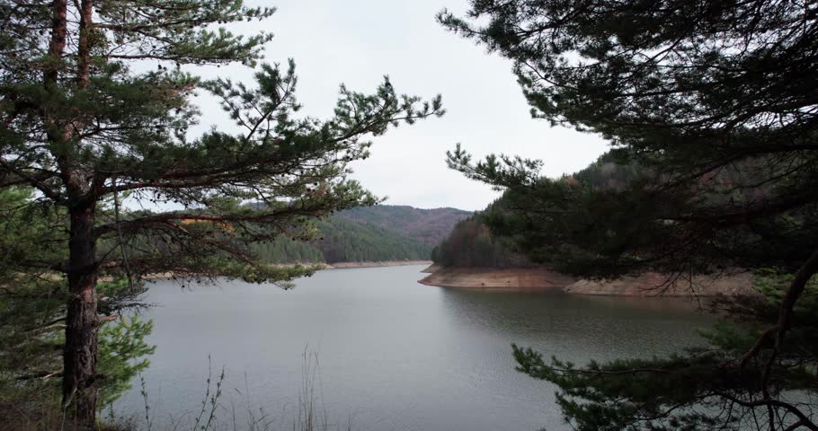 Panorama of mountain lake surrounded by forested hills and scenic natural landscapes