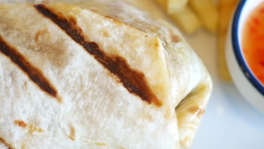 detail shot of chicken wrap with fries 
