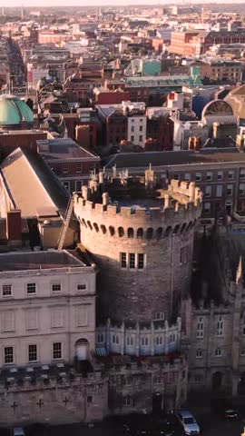 Dublin Castle round tower in warm light, drone vertical over the square. Historical landmark.
