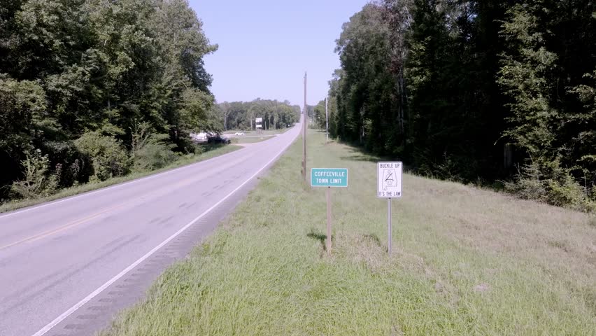 Coffeeville, Alabama town limit sign with drone video moving in up high.